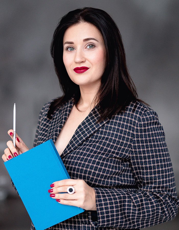 a-woman-with-dark-hair-in-a-jacket-holds